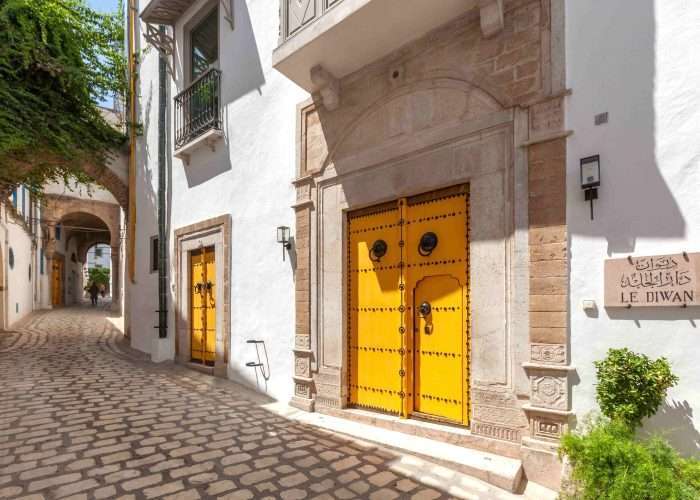 Voyages prestige - Entree de l hotel de charme de Dar El Jeld avec sa porte cloutee jaune