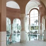 piscine interieure de l hotel residence a tunis avec des colonnes en marbre rose et mosaique blanche